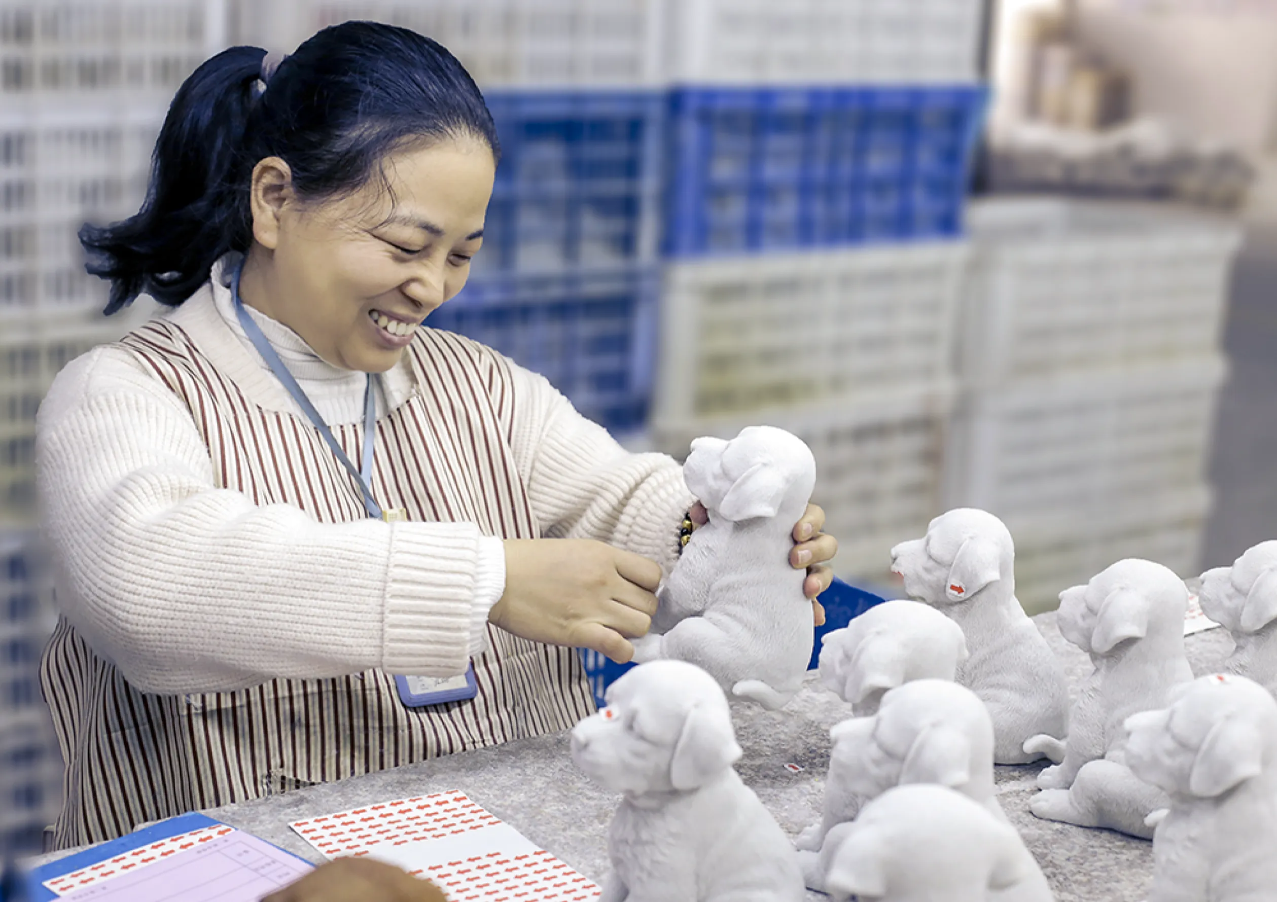 Smiling woman works on dog figurines